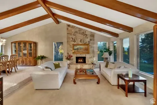 Spacious living room featuring beamed vaulted ceiling, plenty of natural light.