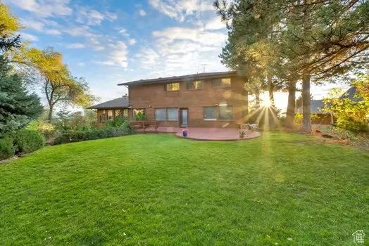 Spacious backyard and view of large deck and BBQ area.  Upper level of yard.