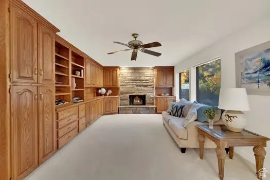 Family Room section of large open Great Room featuring custom wood cabinets & fireplace and lots of windows with  fantastic back-yard view