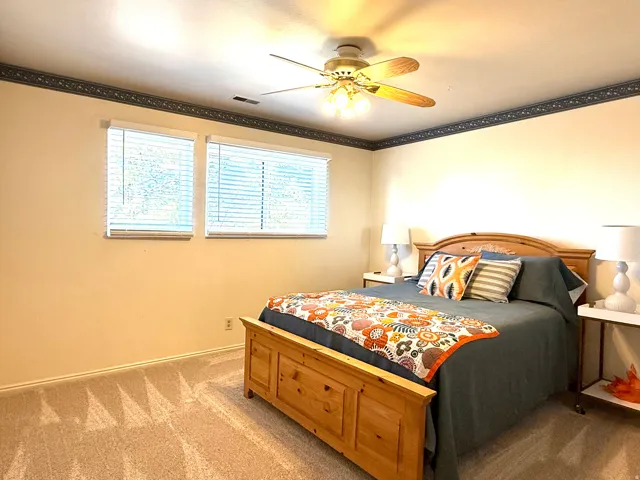 Onw of 4 upstairs bedrooms with new carpet, crown molding  and  ceiling fan.