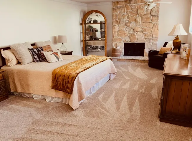 Bedroom with new carpet, a fireplace, and ornamental molding