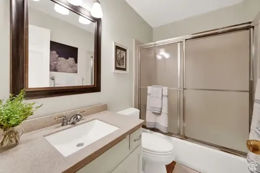 Full bath with vanity and shower / bath combination with glass door