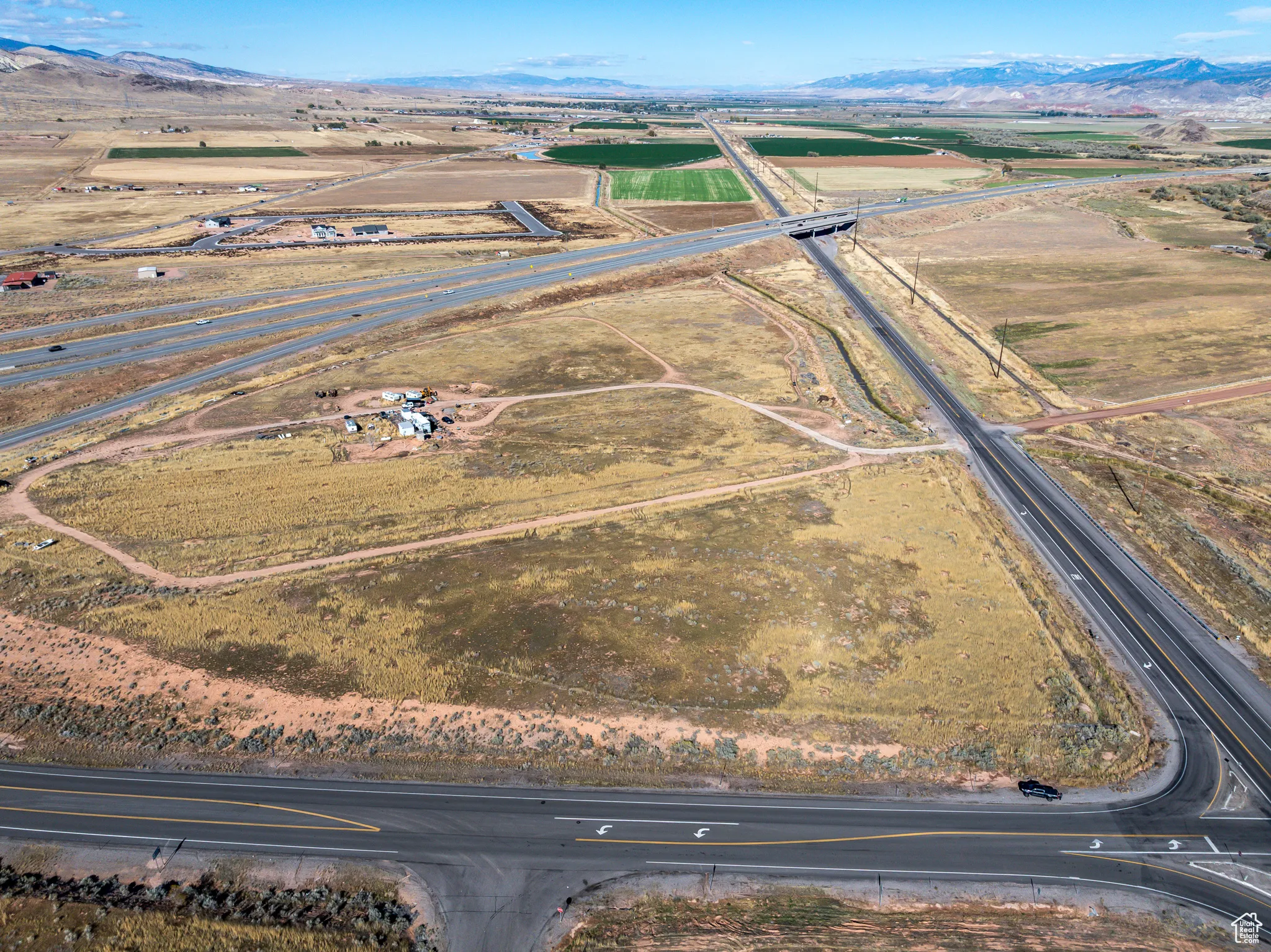 Aerial overview of property's location featuring a mountainous background and rural landscape