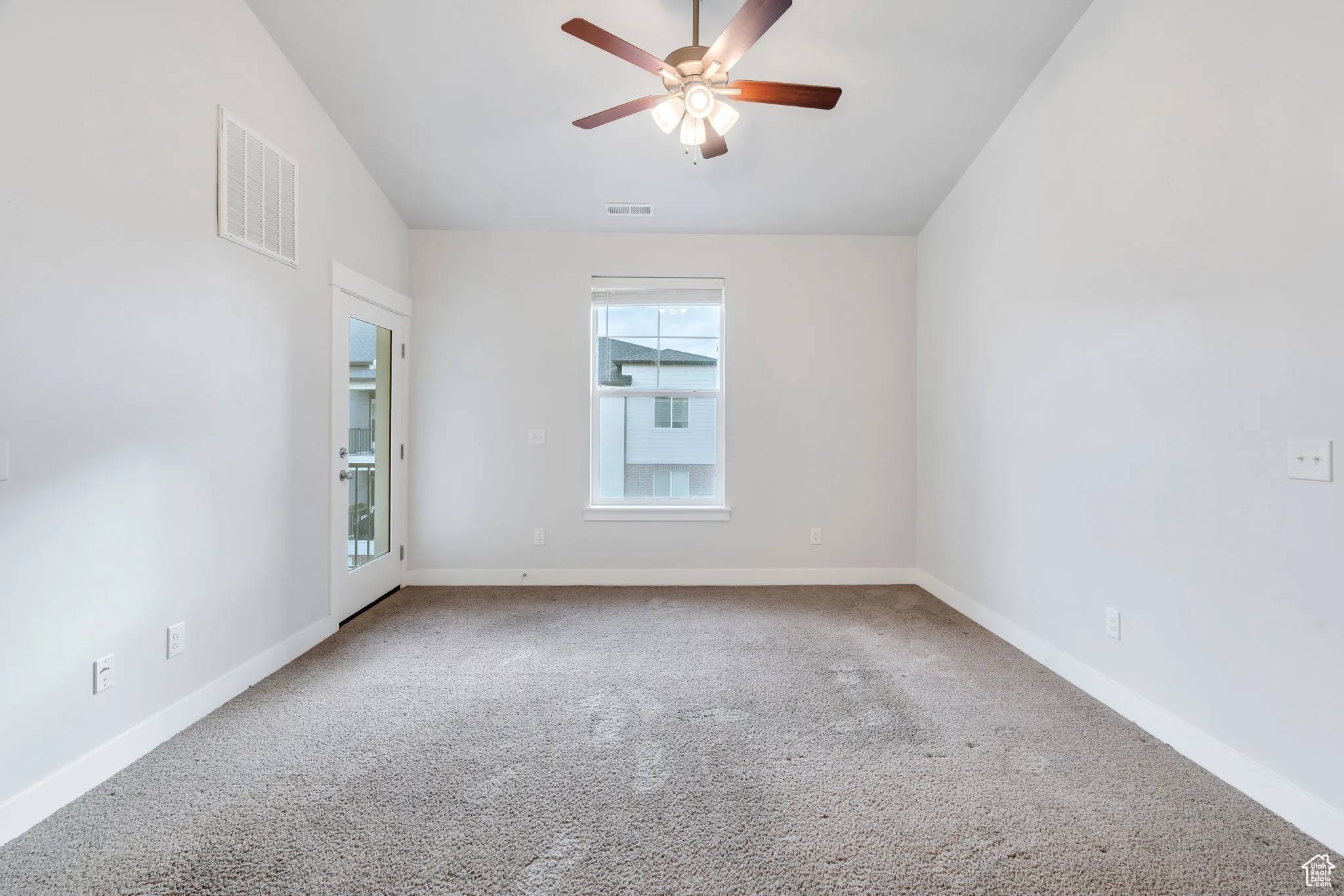 Living room with lots of light and a door to the balcony. Seller will replace the carpet.