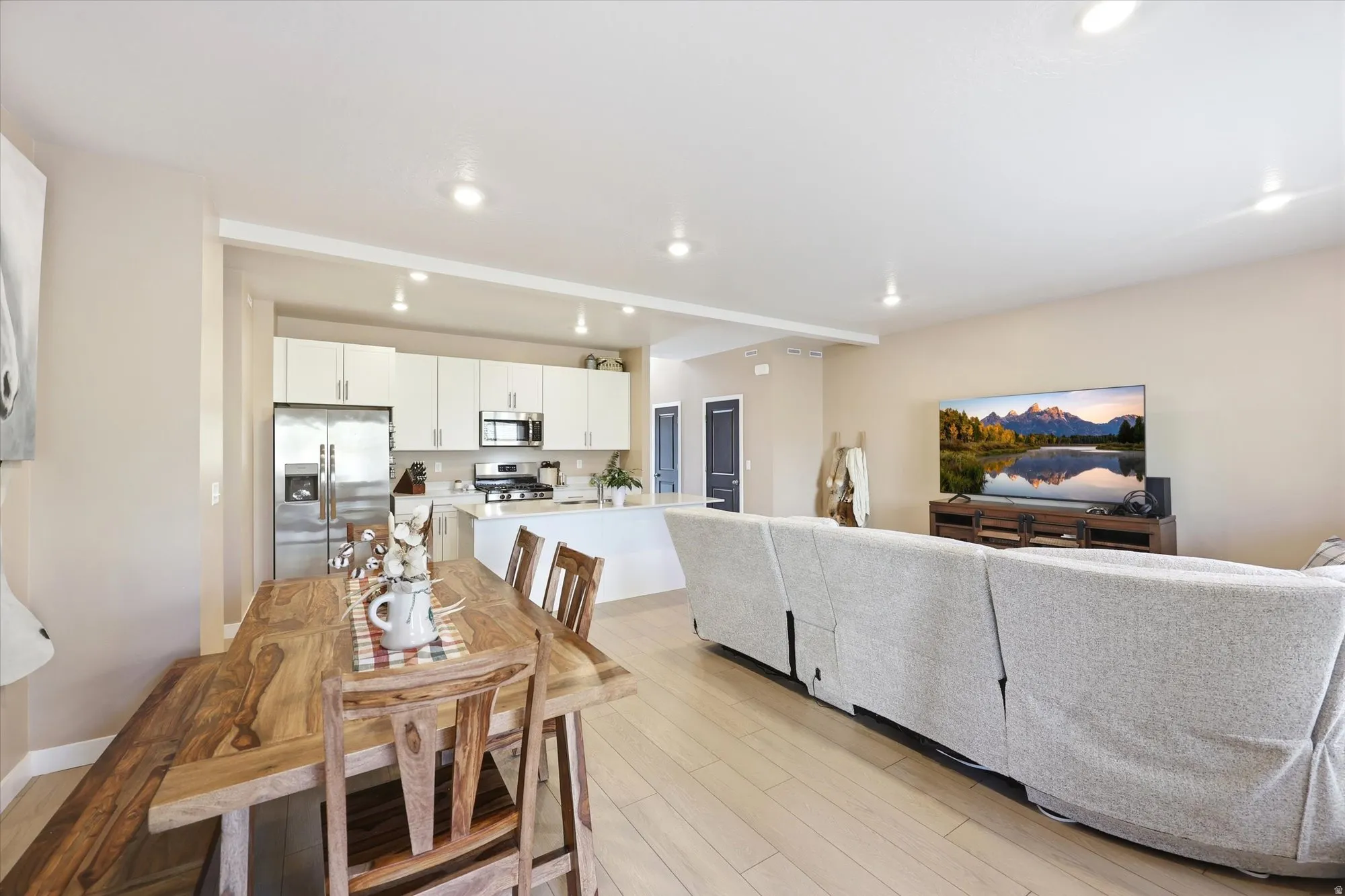 Open-concept living area with light wood-finish flooring