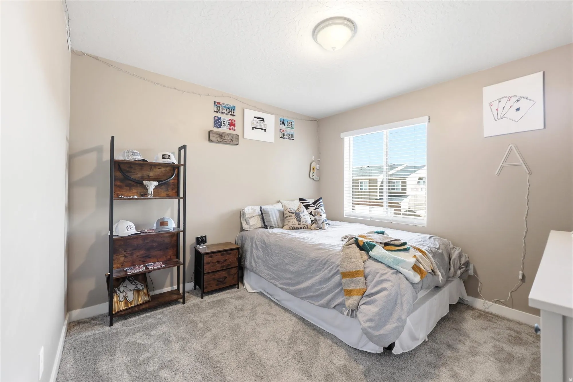 Recessed window with white blinds, neutral wall paint, and gray carpet flooring