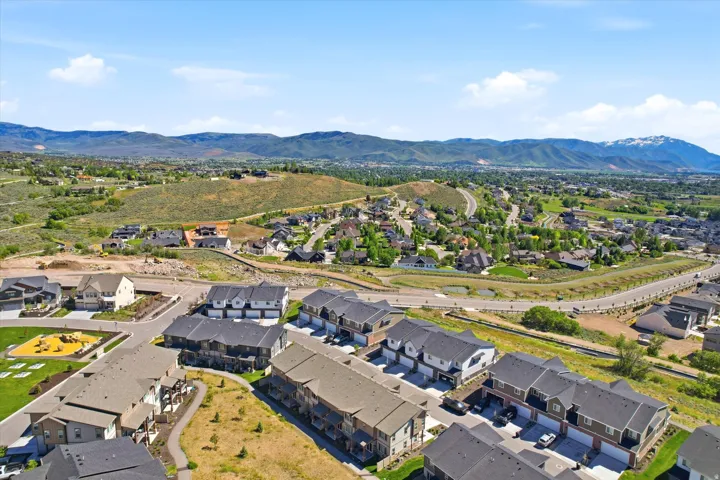 Expansive aerial perspective showcasing a residential development with mountainous backdrops
