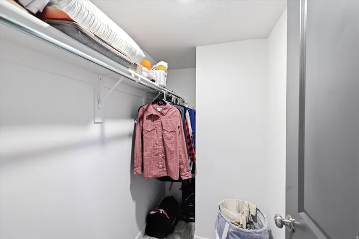 Recessed closet with a single hanging rod and upper storage shelf