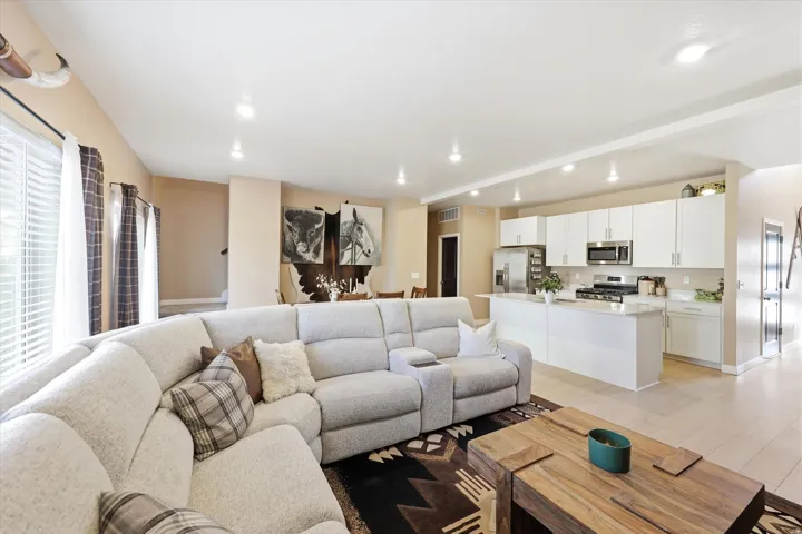 Open-concept living area featuring light-toned walls and recessed lighting
