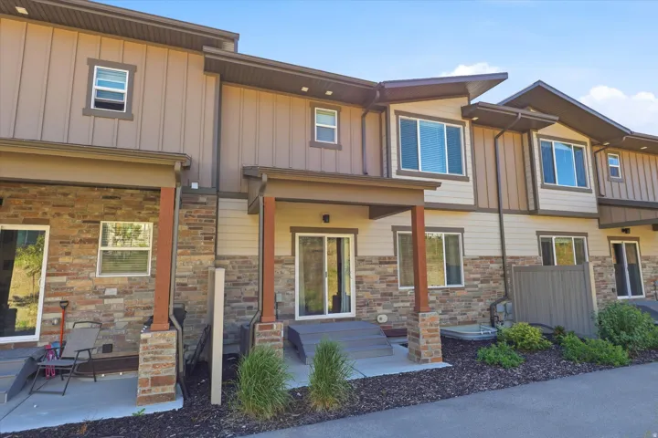 Contemporary townhome exterior featuring stone accents and horizontal siding