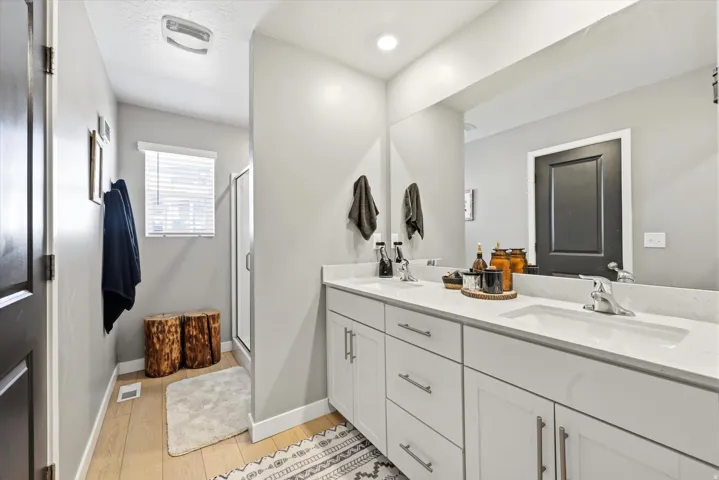 Bathroom featuring a dual vanity with white cabinetry and a light-colored countertop