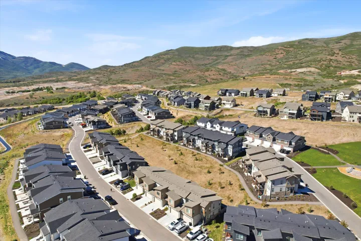 Expansive development featuring a variety of contemporary homes and townhomes, surrounded by natural hillsides