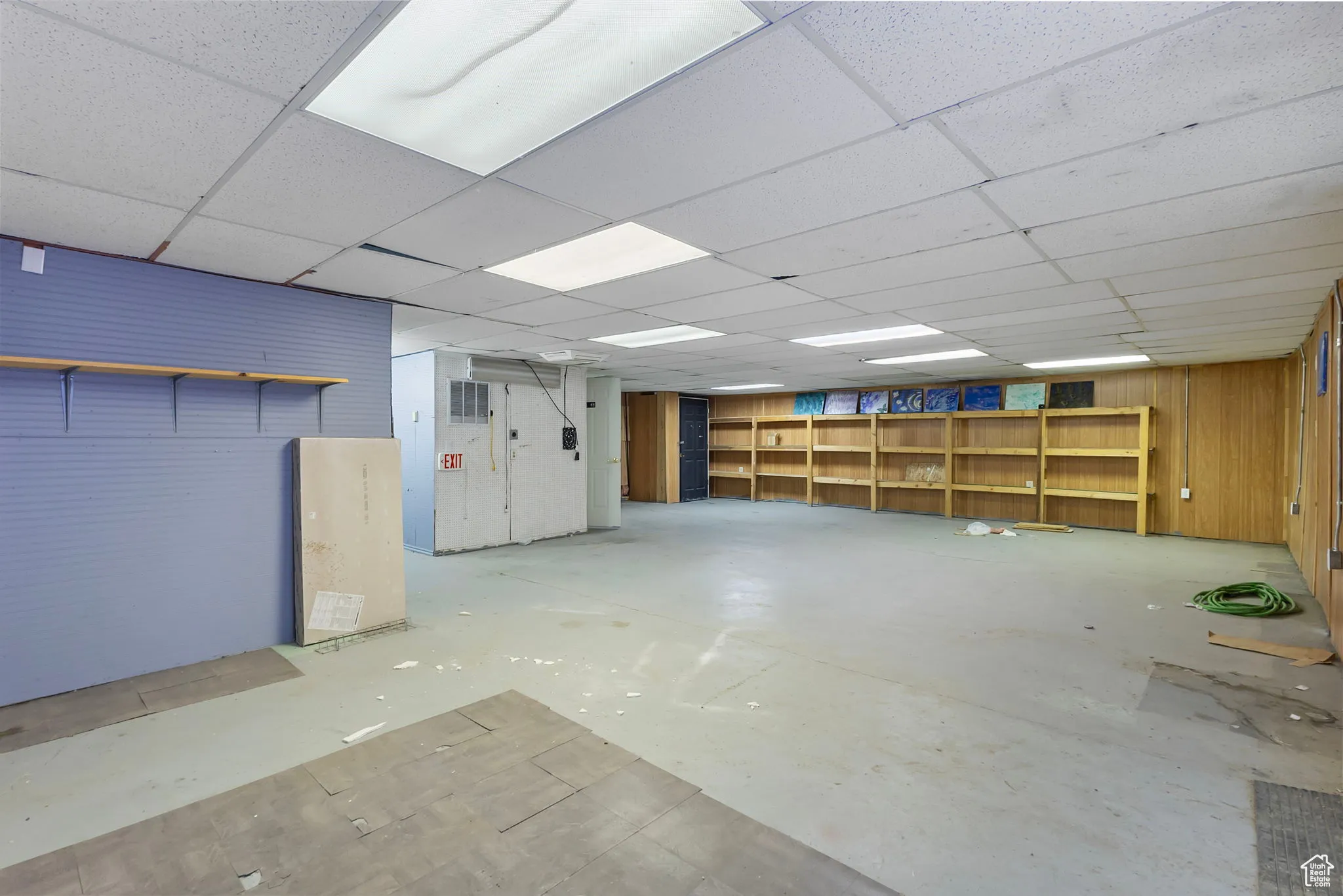 Below grade area featuring wood walls and a drop ceiling