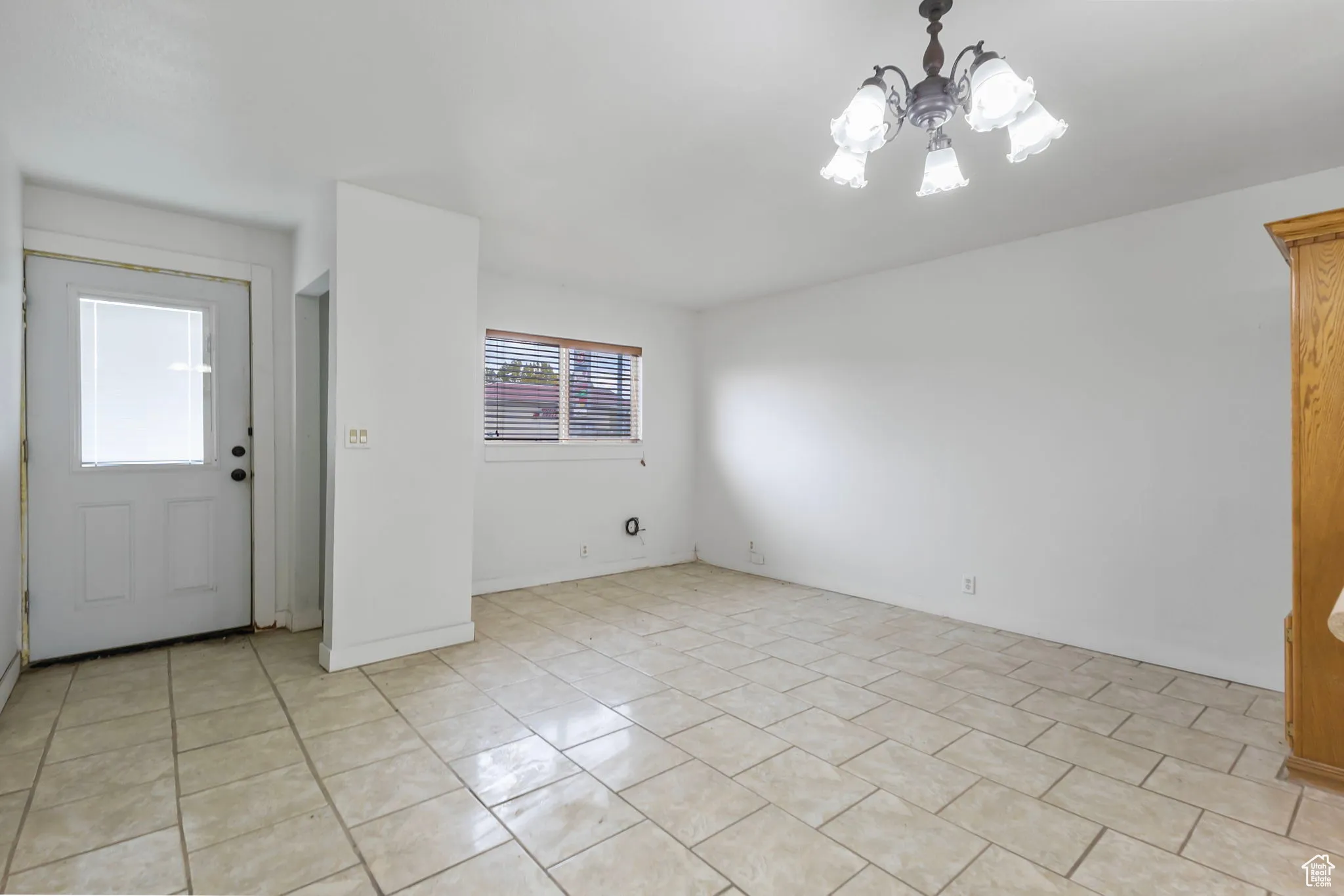 Unfurnished room featuring a chandelier and light tile patterned flooring