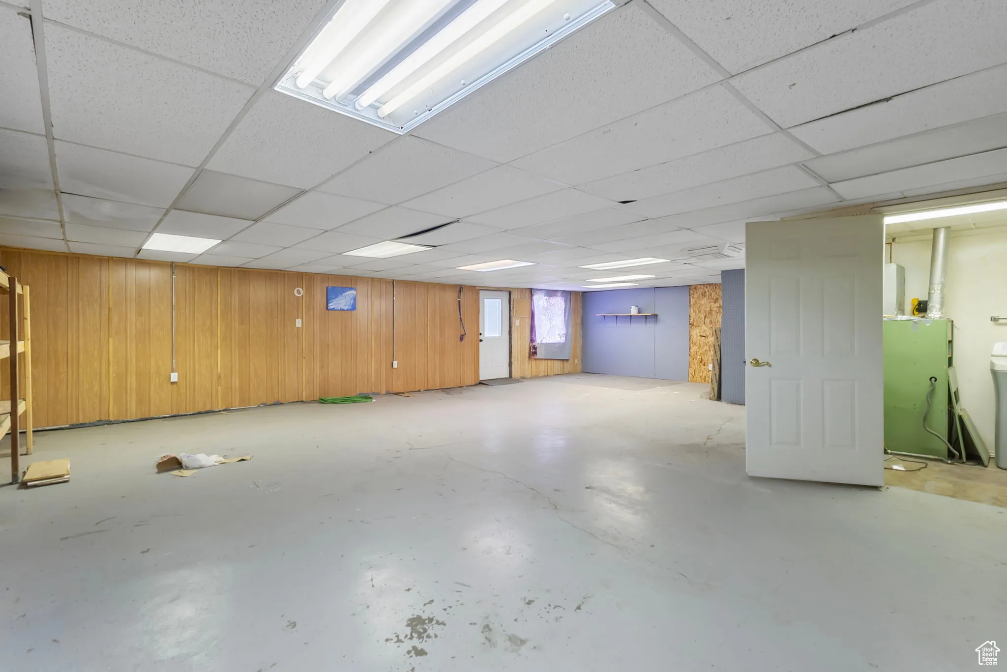 Basement with wooden walls and a paneled ceiling