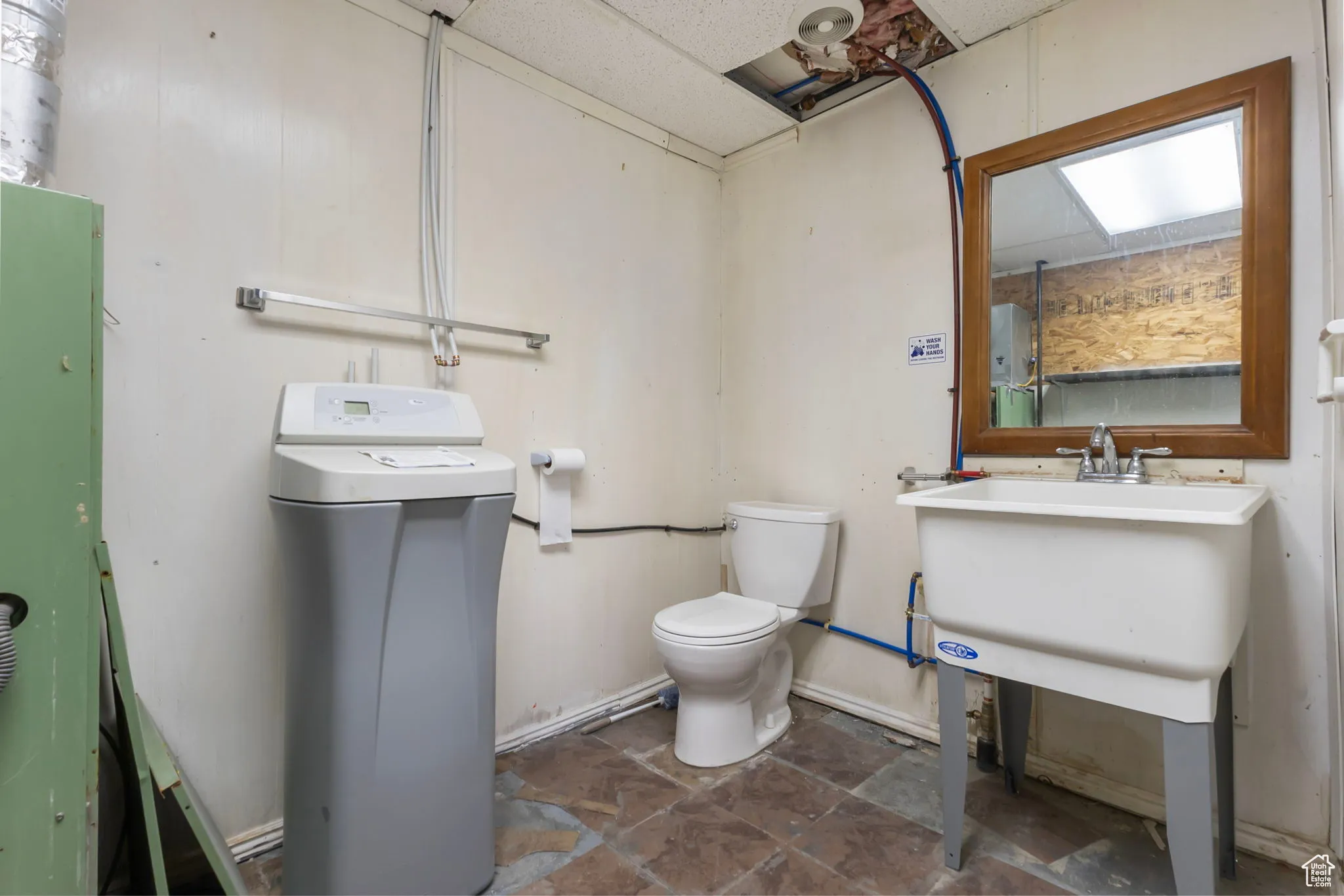 Bathroom featuring toilet and dark stone finish flooring