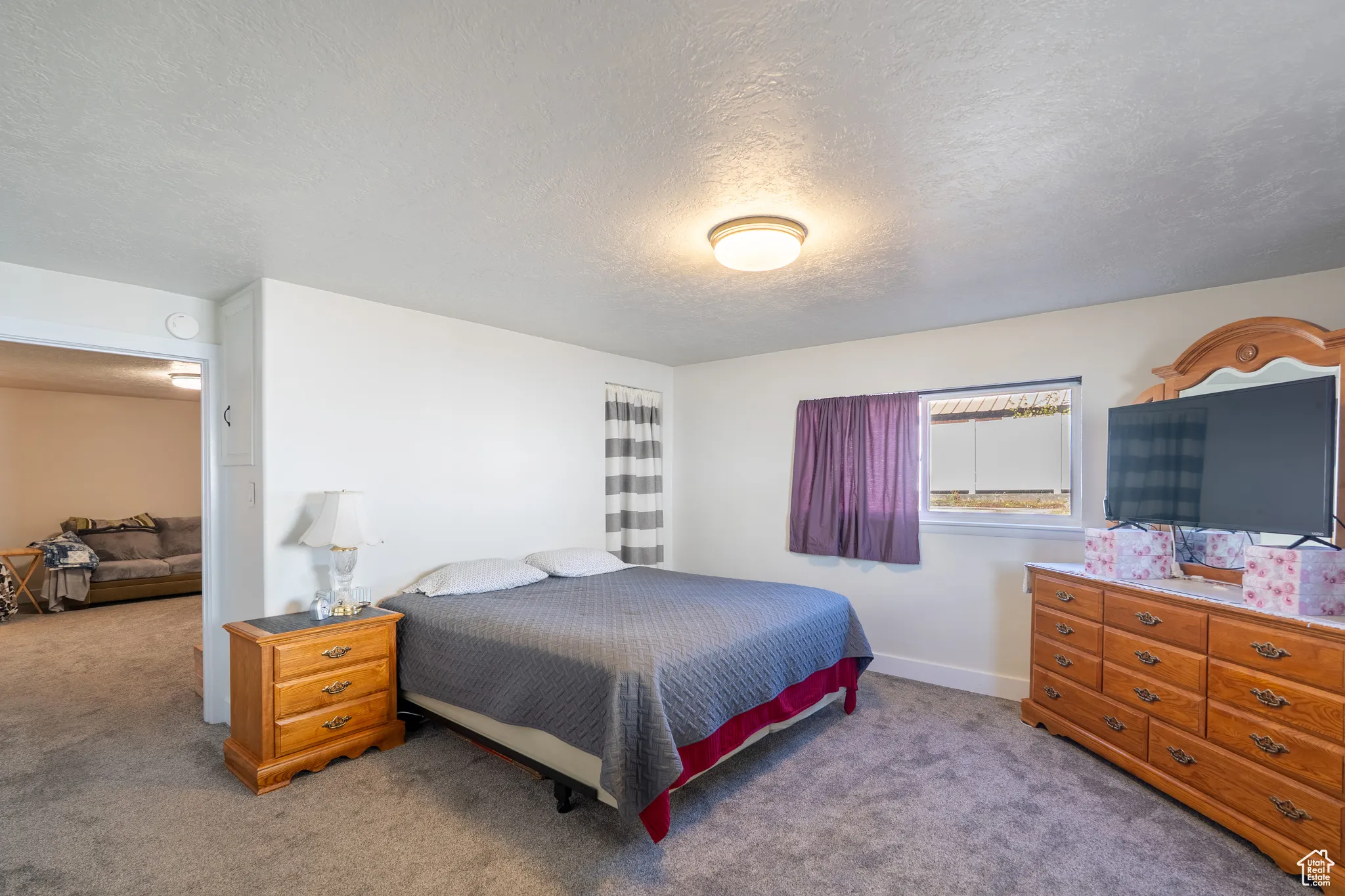 Bedroom featuring a textured ceiling and light colored carpet