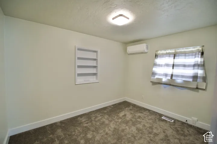 Recessed wall shelving, wall-mounted air conditioning unit, window, and flush-mount ceiling light