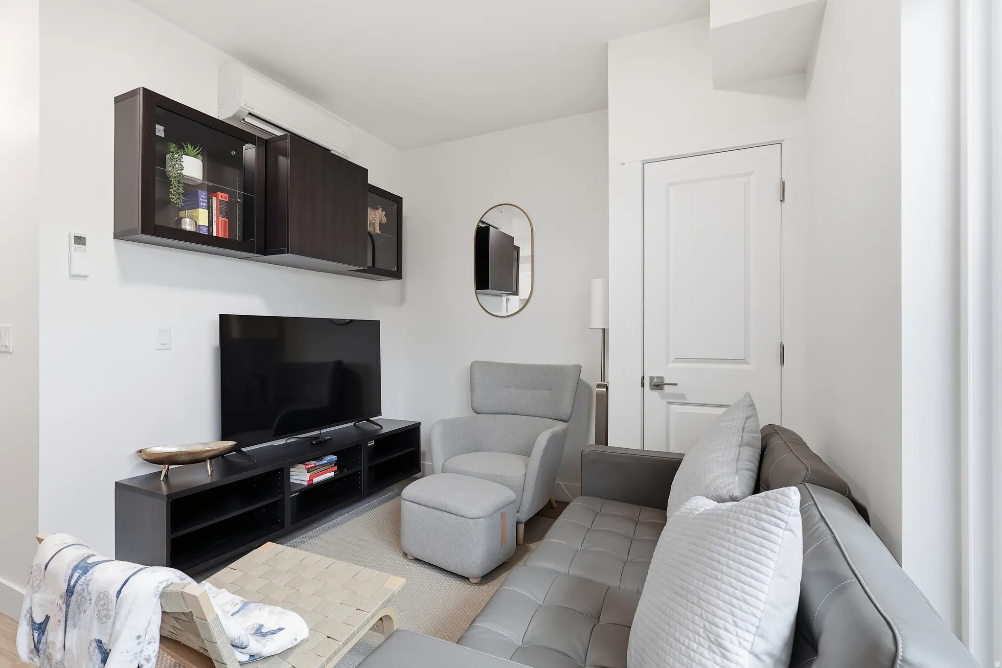 Living room with a wall mounted mini split and light colored carpet