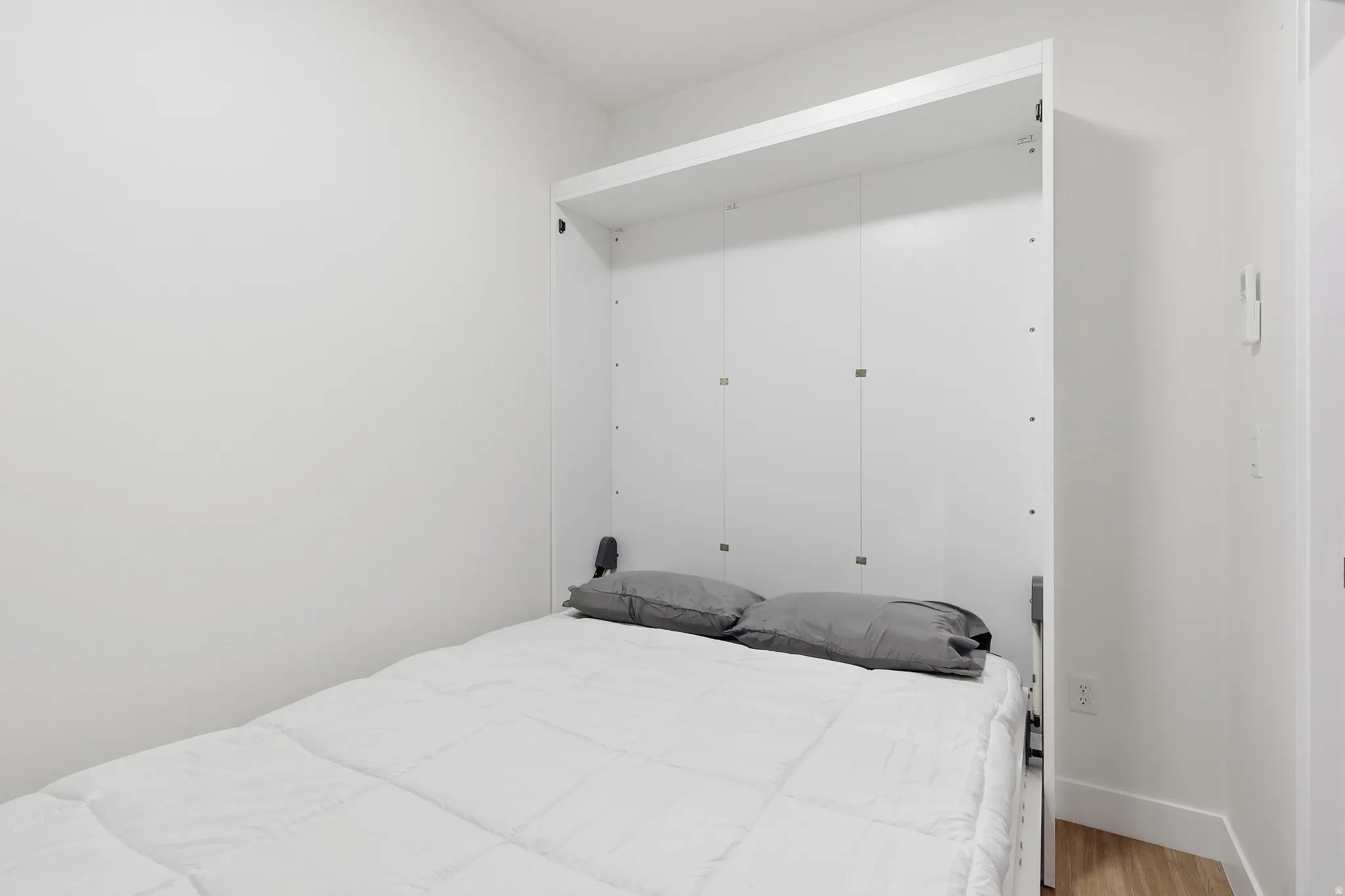 Plus one by night / Murphybed with wood finished floors and a closet