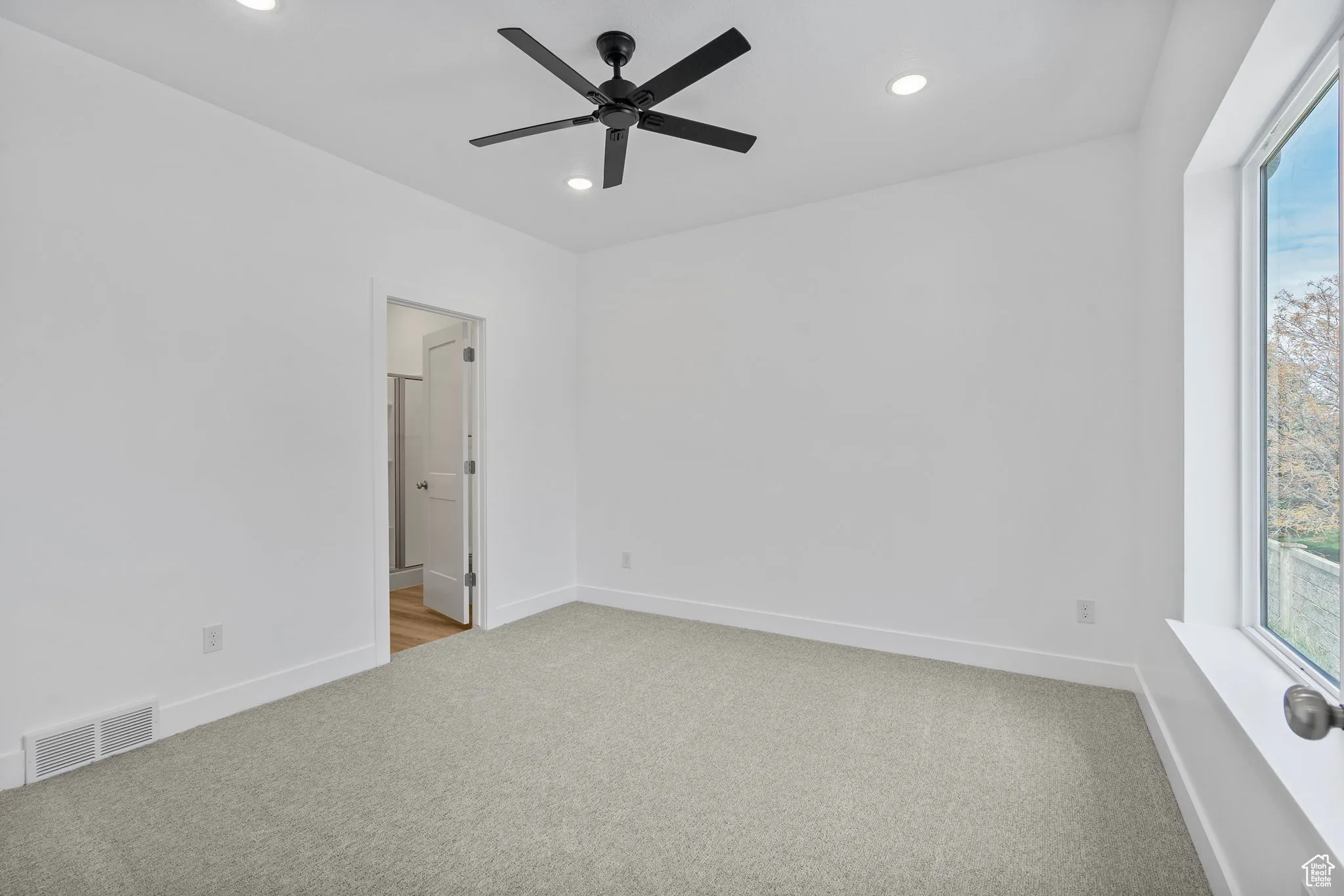 Empty room with light colored carpet, recessed lighting, and a ceiling fan