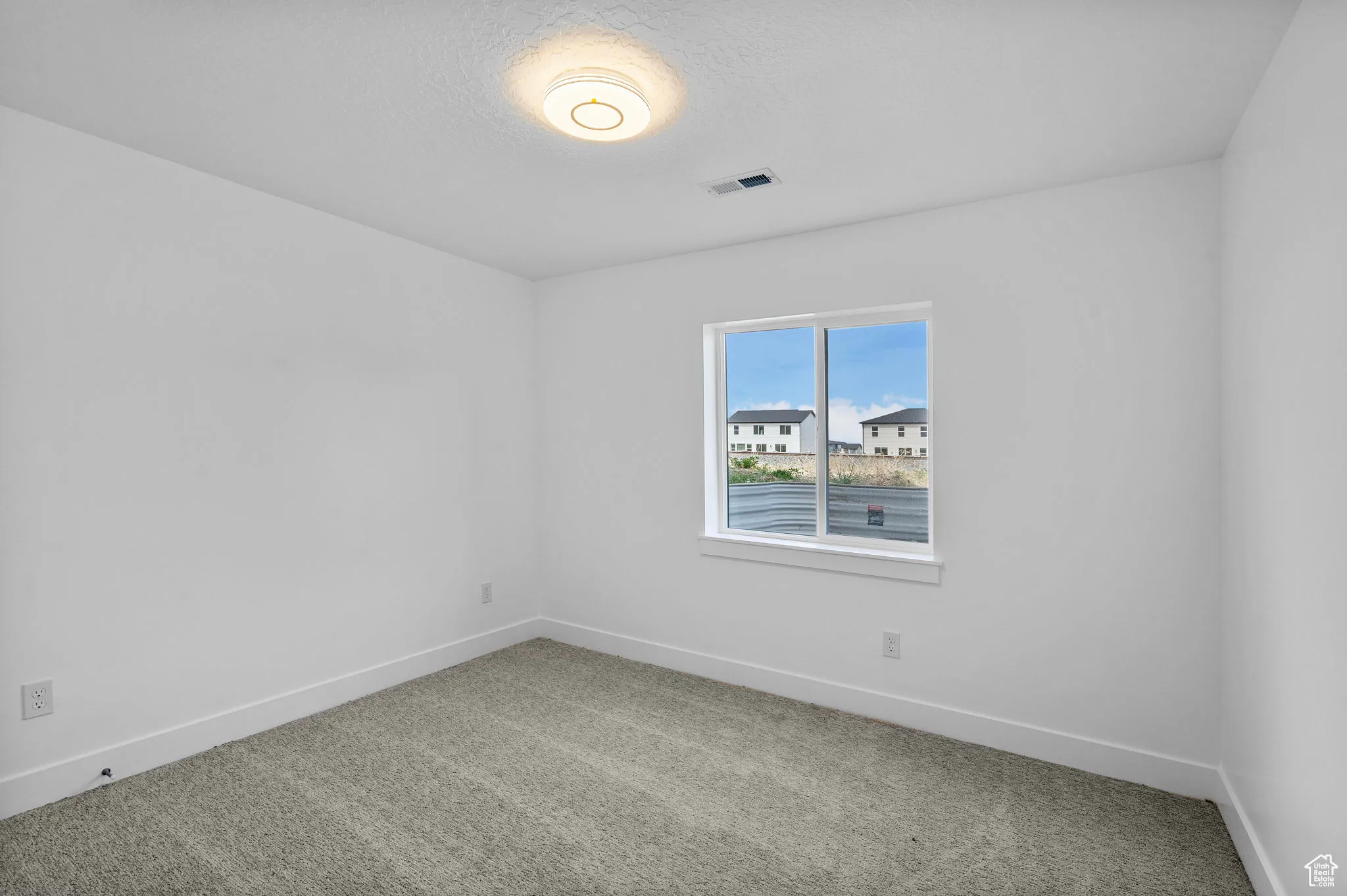 Spare room featuring carpet flooring and a textured ceiling