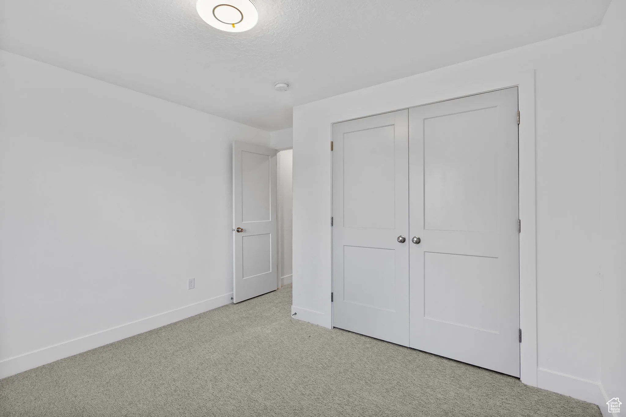Unfurnished bedroom featuring carpet flooring, a closet, and a textured ceiling