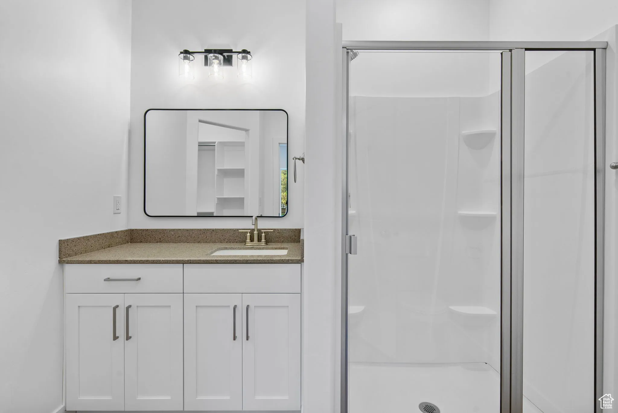 Bathroom featuring vanity and a shower stall