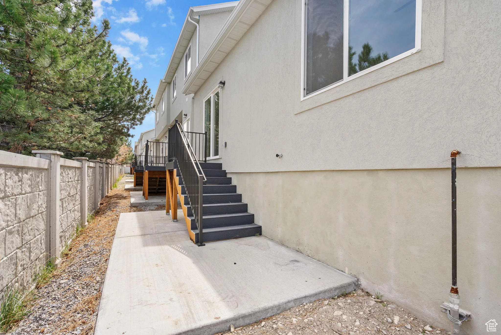 View of side of property with stucco siding and a patio