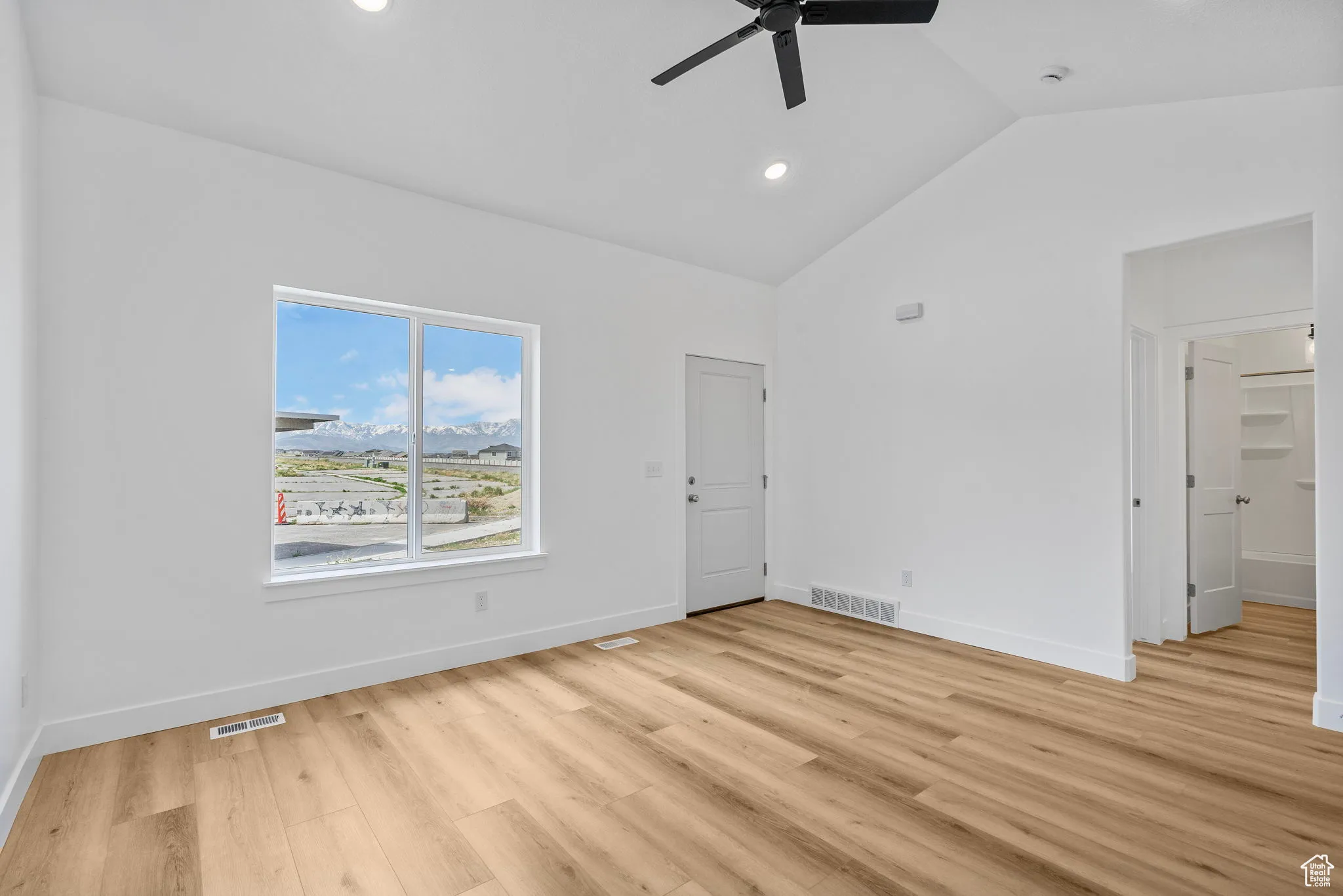 Unfurnished room with recessed lighting, light wood finished floors, a ceiling fan, and high vaulted ceiling