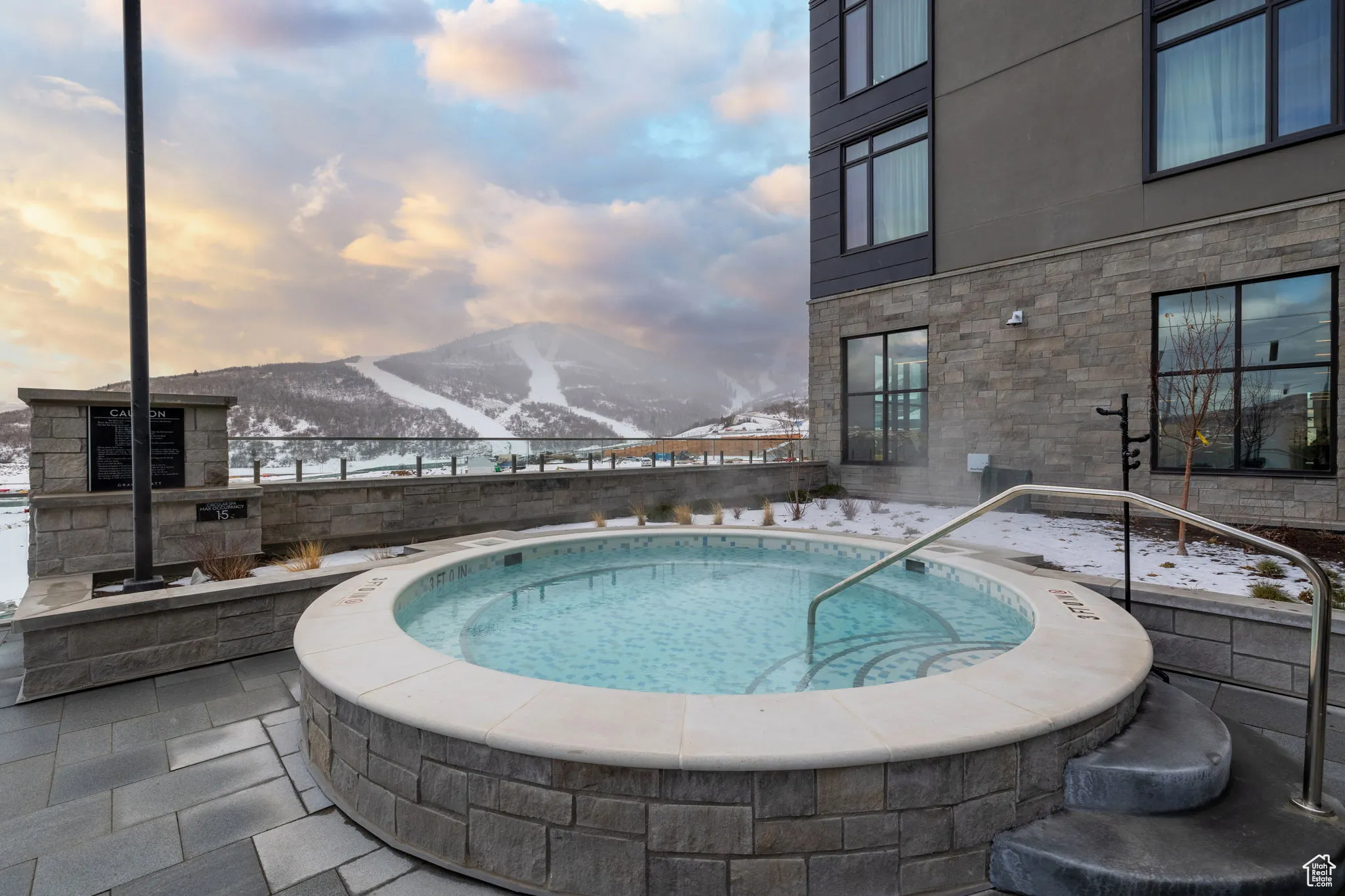 Outdoor heated pool with a mountain view, a hot tub, and patio