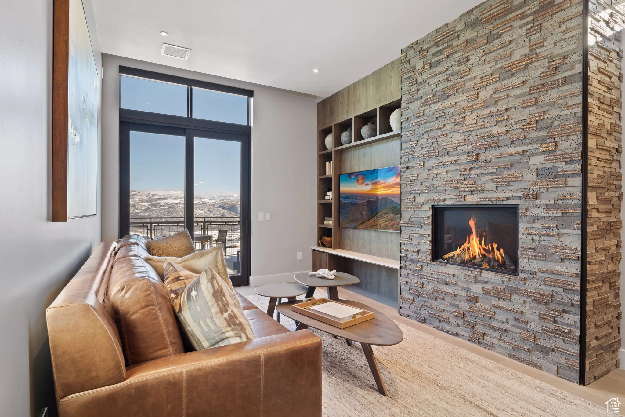 Living area featuring a fireplace, built in features, and wood  floors