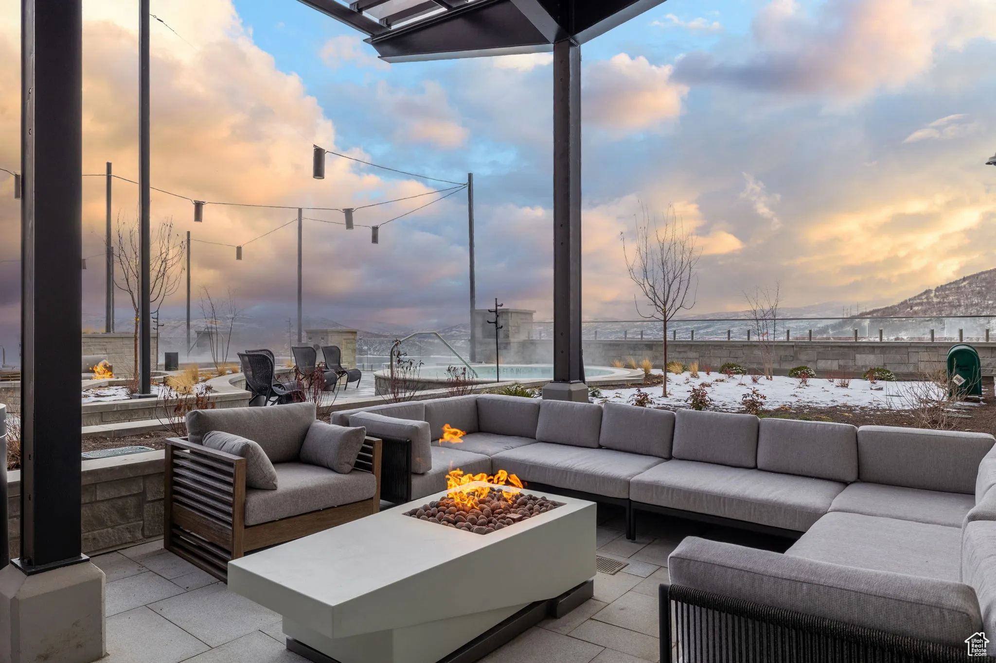Patio terrace at dusk featuring an outdoor living space with a fire pit, a patio area, and a mountain view