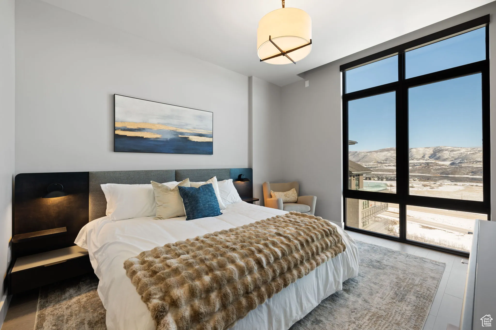 Bedroom with floor to ceiling windows, a mountain view, and wood finished floors