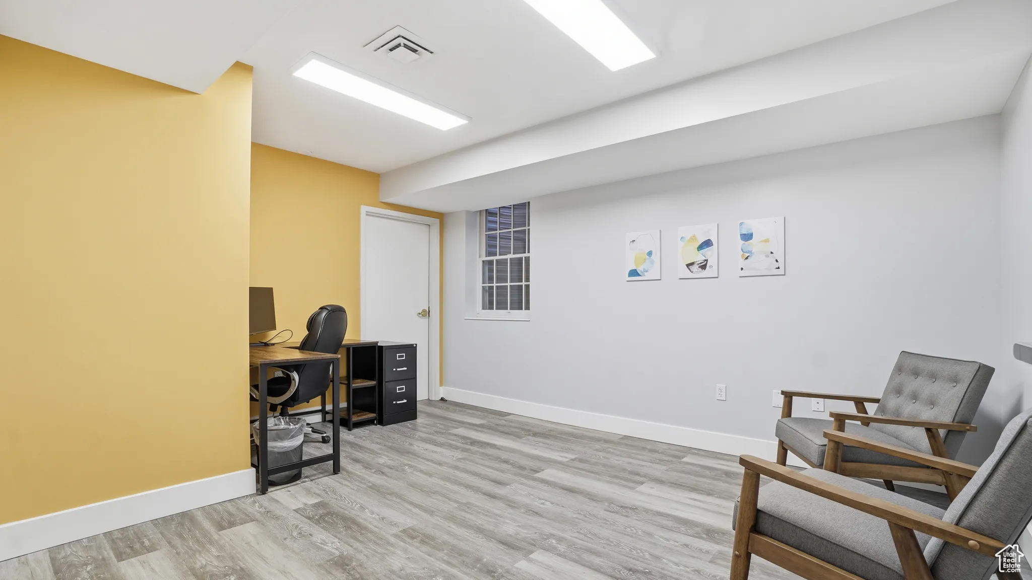 Home office featuring light wood-type flooring and baseboards