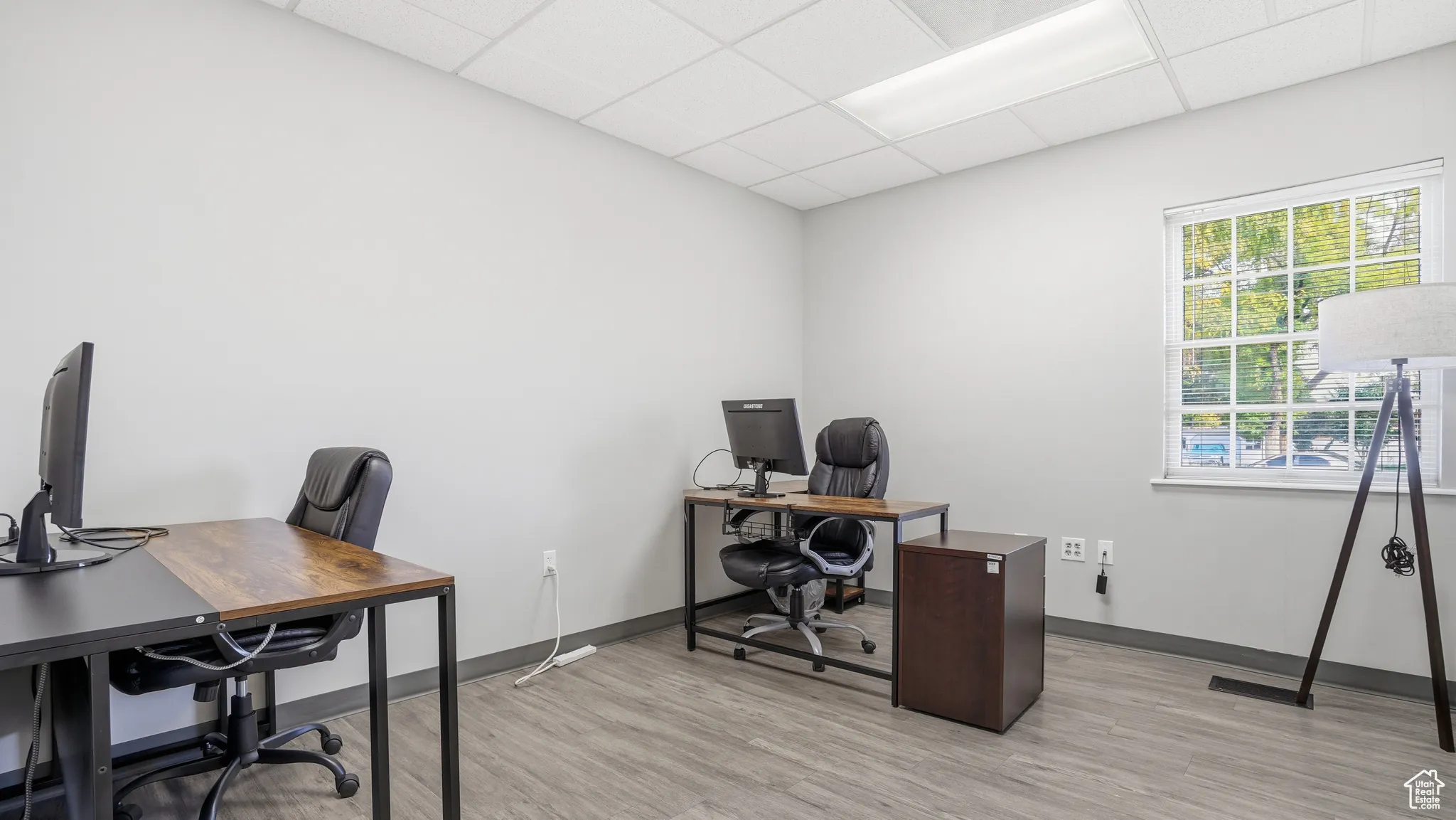 Office space with a paneled ceiling and light wood-style floors