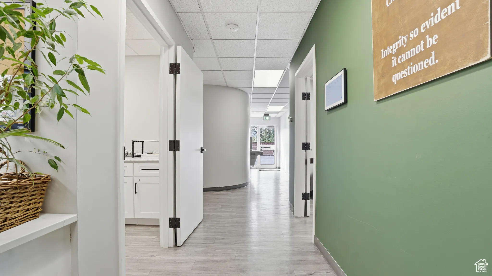 Hallway featuring a paneled ceiling and light wood-style flooring