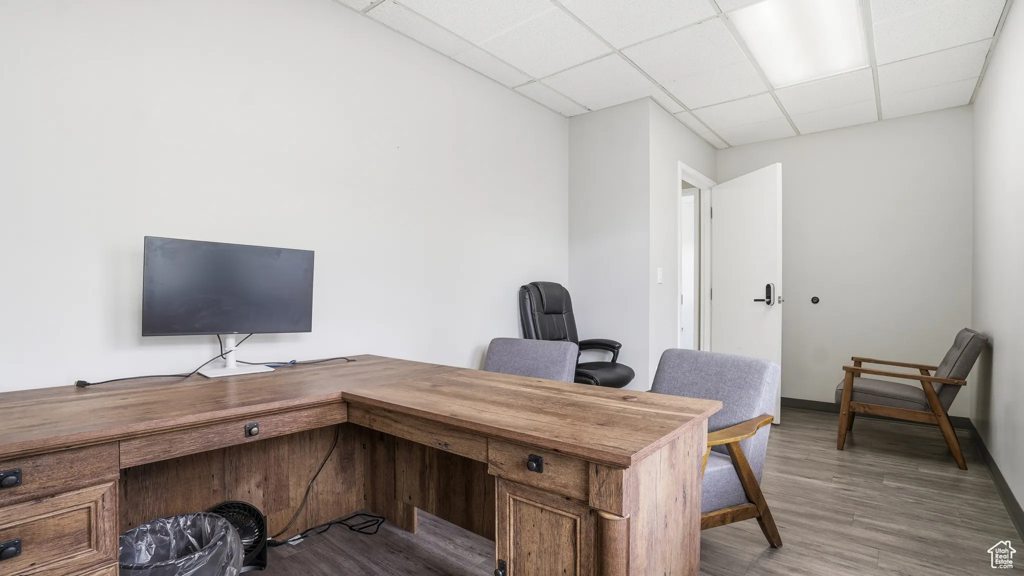Home office featuring a paneled ceiling and dark wood-style flooring