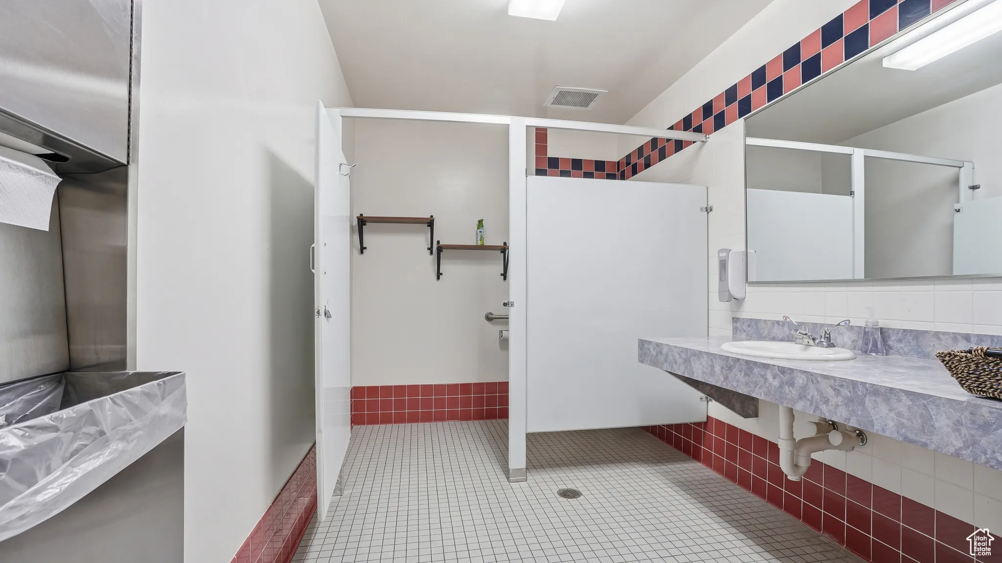 Full bathroom featuring a stall shower, vanity, light tile patterned flooring, and pet washing station