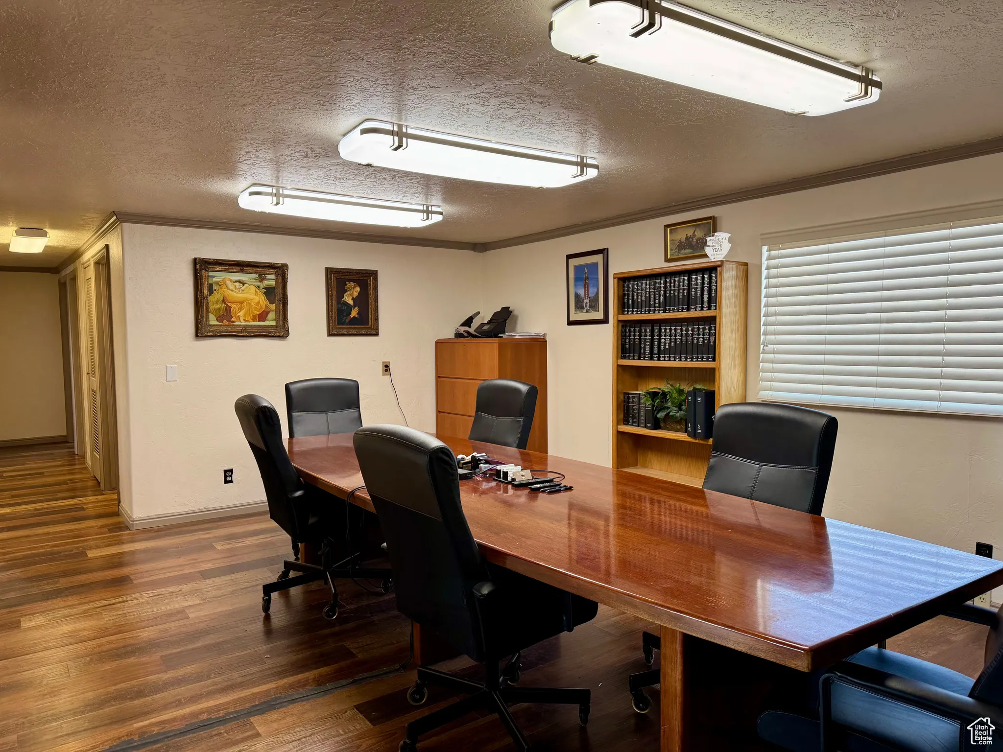 Office space featuring a textured ceiling, ornamental molding, and wood finished floors