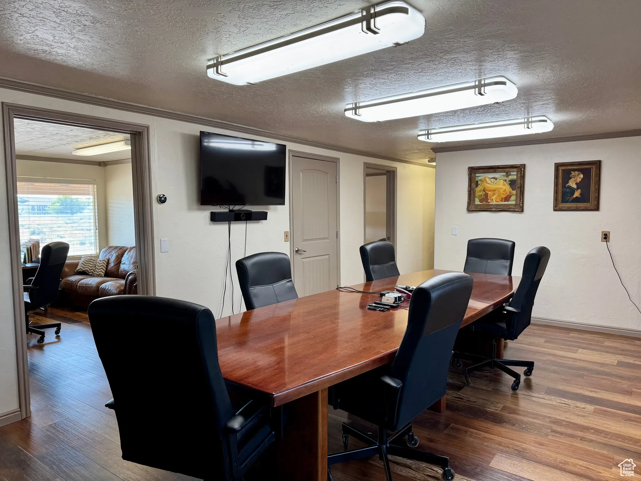 Office area featuring a textured ceiling, wood finished floors, and crown molding