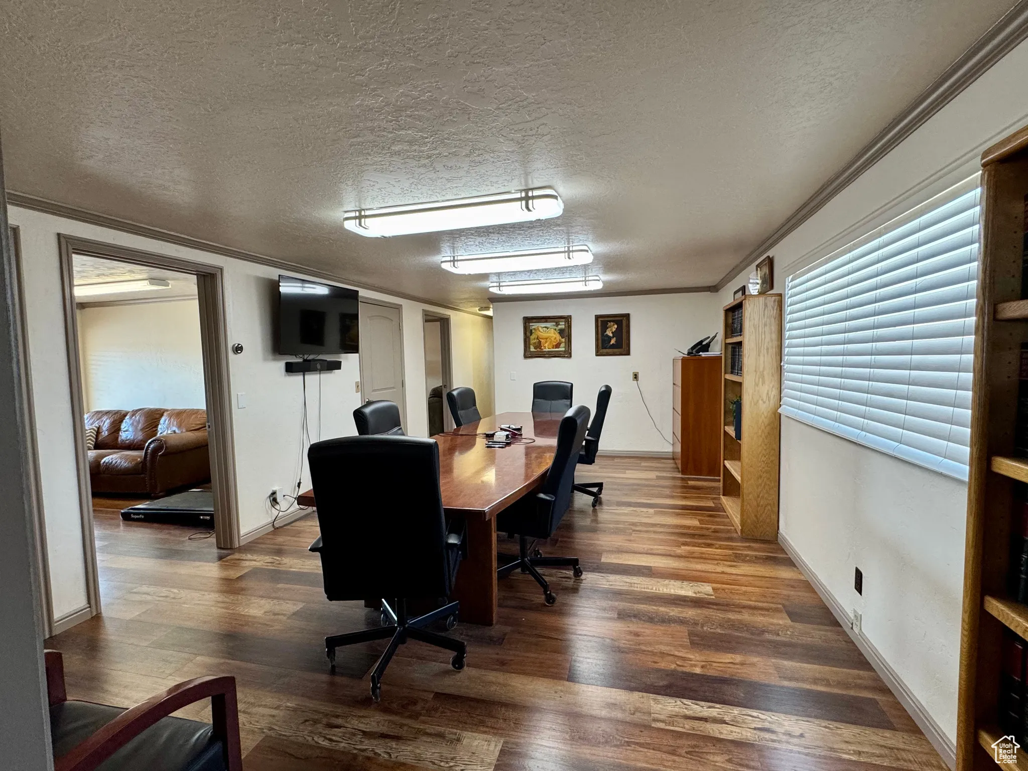 Office space featuring a textured ceiling, wood finished floors, and ornamental molding