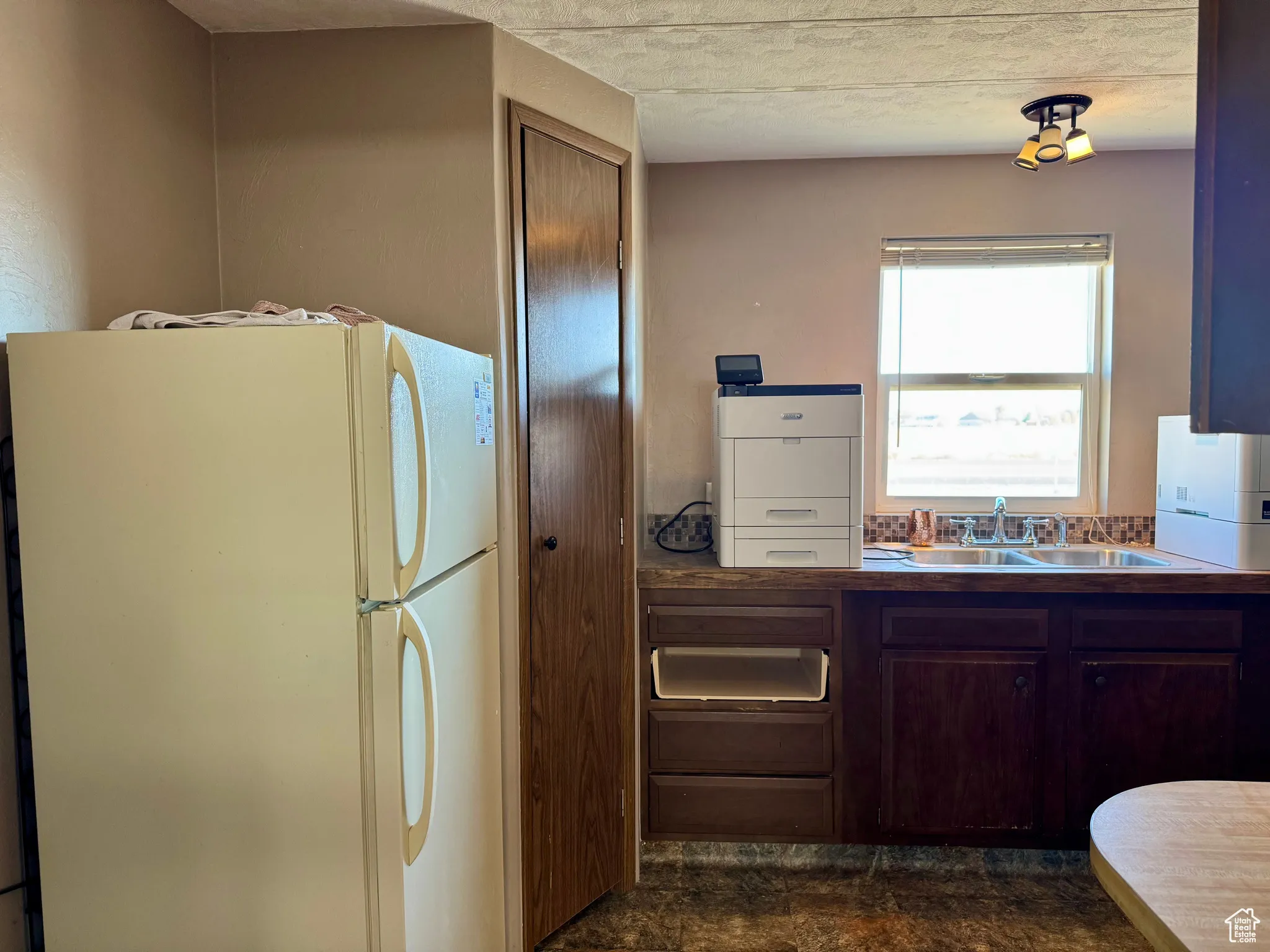 Kitchen with freestanding refrigerator and a sink