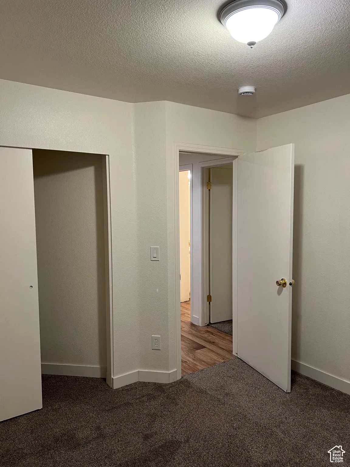 Bedroom 3 featuring dark colored carpet, a textured ceiling, and a smoke detector