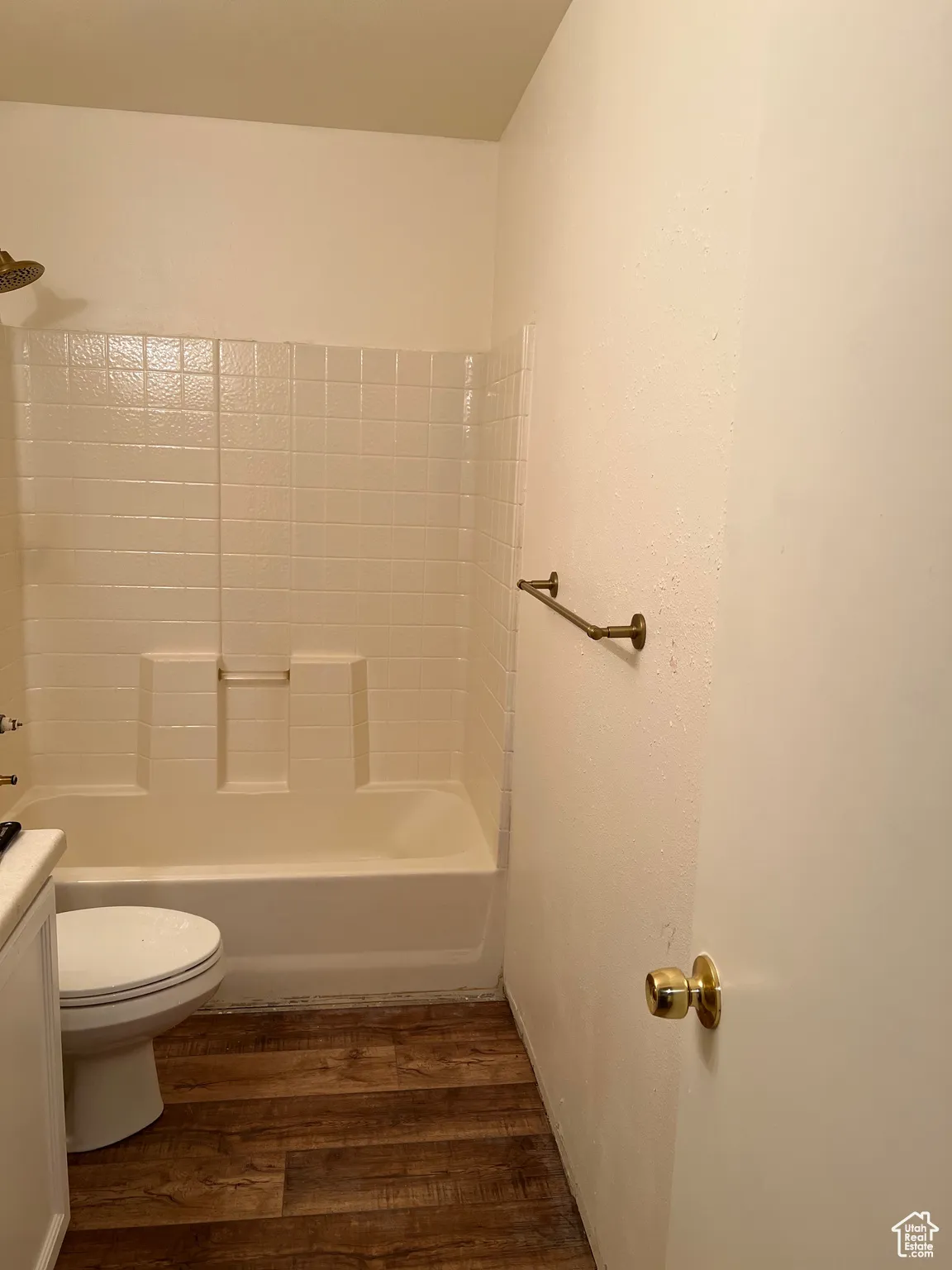 Full bath featuring dark wood finished floors, shower / bathtub combination, and vanity