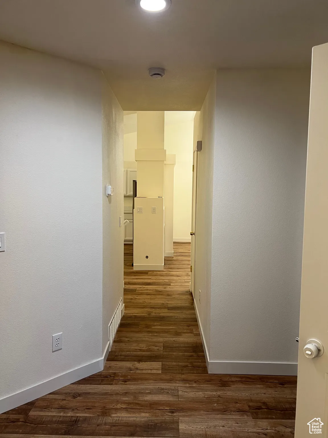 Hall with dark wood-style flooring and recessed lighting
