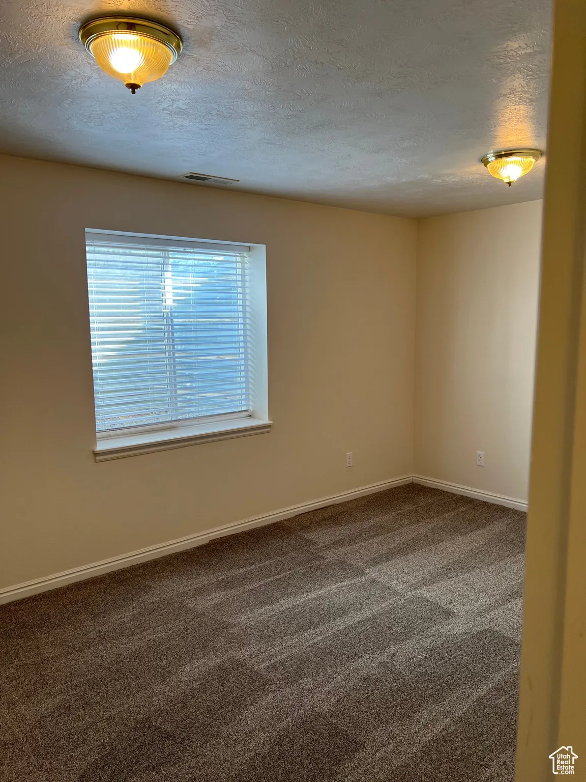 Bedroom 4 featuring dark carpet and a textured ceiling