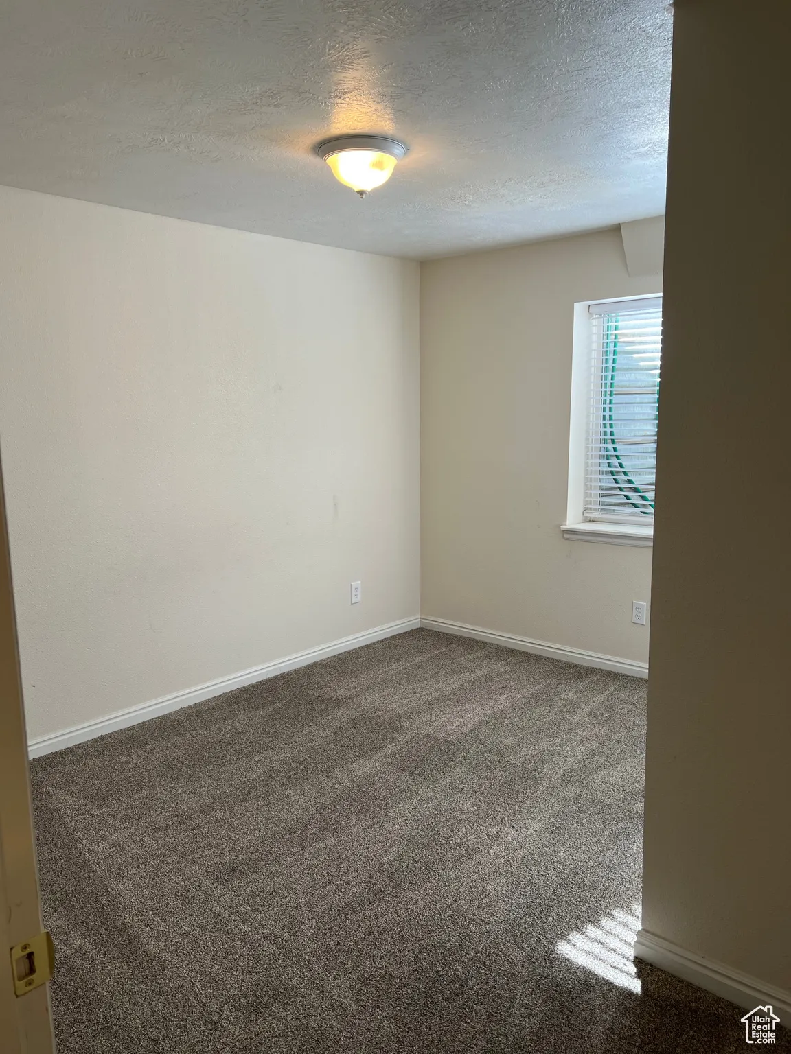 Bedroom 4 featuring dark colored carpet and a textured ceiling