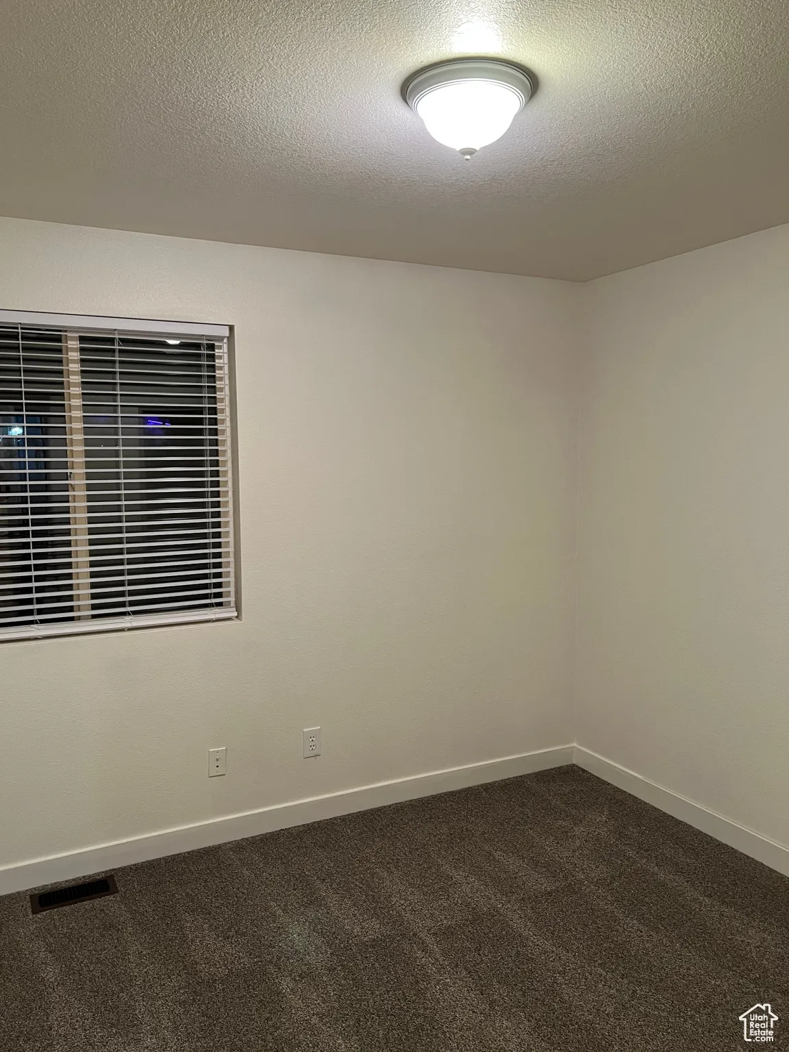 Bedroom 3 room featuring dark carpet and a textured ceiling