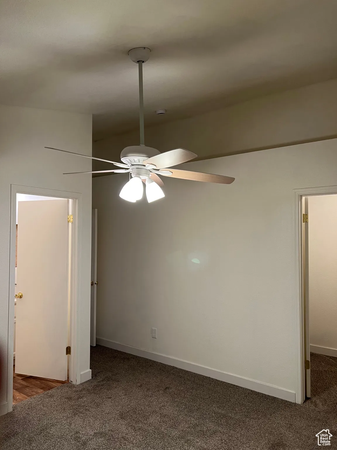 Unfurnished Master bedroom featuring dark carpet and a ceiling fan